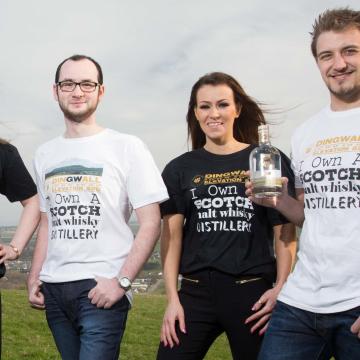 Four members of Glenwvis Distillery holding bottles of whiskey