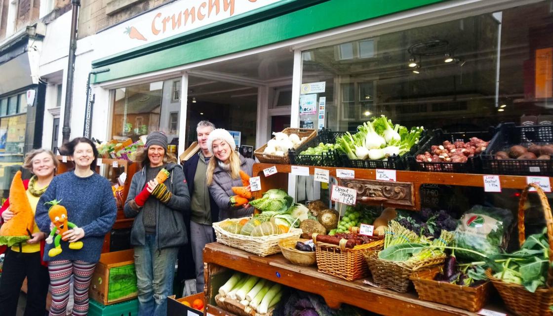 Group of people stood outside a greengrocers