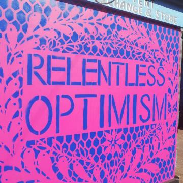 Pink and blue mural saying RELENTLESS OPTIMISM in capital letters